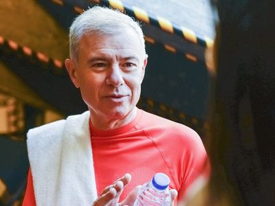 Water bottle and towel on a bench in gym